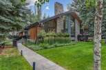 Experience modern luxury in this stunning home featuring a striking stone chimney and expansive windows that invite natural light.