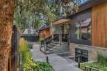 Experience modern luxury in this stunning home featuring a sleek dark exterior with warm wood accents.