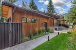 Experience modern luxury in this stunning home featuring warm wood siding and sleek black accents.