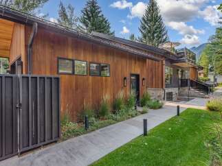 Experience modern luxury in this stunning home featuring warm wood siding and sleek black accents.