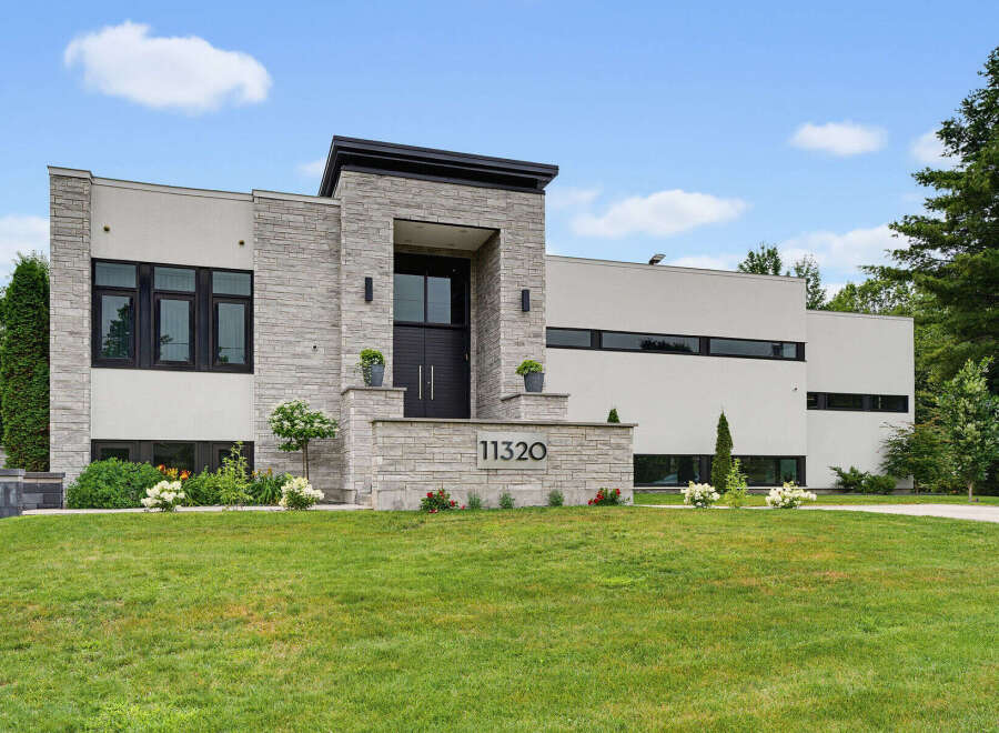 Discover modern luxury in this stunning architectural masterpiece, featuring a striking facade of stone and stucco.