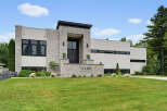 Discover modern luxury in this stunning architectural masterpiece, featuring a striking facade of stone and stucco.
