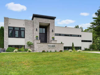 Discover modern luxury in this stunning architectural masterpiece, featuring a striking facade of stone and stucco.