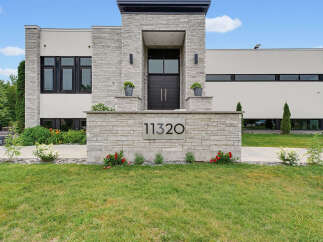 Experience modern luxury in this stunning residence featuring a striking stone facade and expansive windows.