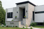 Discover modern luxury in this stunning home featuring a striking stone facade and sleek architectural lines.