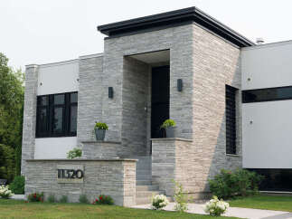 Discover modern luxury in this stunning home featuring a striking stone facade and sleek architectural lines.