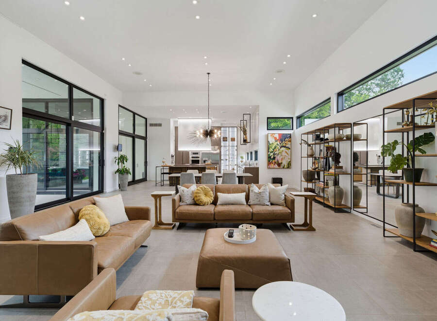 Experience modern luxury in this expansive living room, featuring sleek leather sofas and a large ottoman perfect for gatherings.