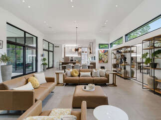 Experience modern luxury in this expansive living room, featuring sleek leather sofas and a large ottoman perfect for gatherings.