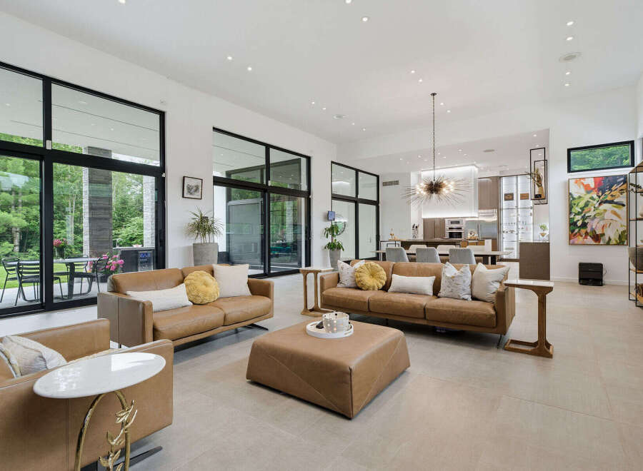 Experience luxurious modern living in this spacious open-concept home, featuring a gourmet kitchen and a stunning living area with floor-to-ceiling windows.