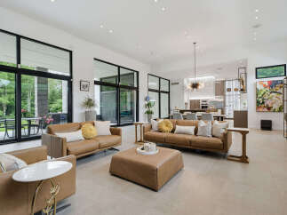 Experience luxurious modern living in this spacious open-concept home, featuring a gourmet kitchen and a stunning living area with floor-to-ceiling windows.
