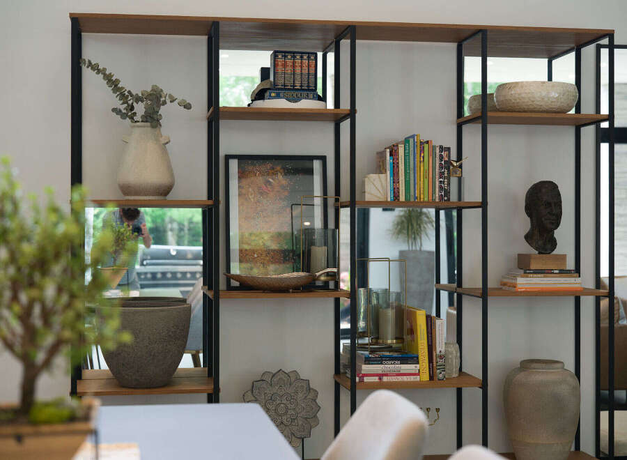 This modern living space features a stylish open shelving unit, perfect for displaying decor and books.