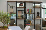 This modern living space features a stylish open shelving unit, perfect for displaying decor and books.