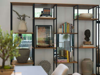 This modern living space features a stylish open shelving unit, perfect for displaying decor and books.