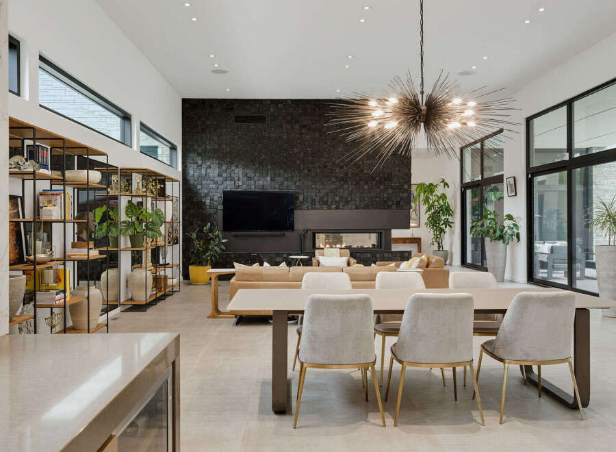 Experience modern luxury in this stunning open-concept living space, featuring a dramatic black stone accent wall with a sleek fireplace and integrated entertainment center.