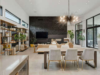 Experience modern luxury in this stunning open-concept living space, featuring a dramatic black stone accent wall with a sleek fireplace and integrated entertainment center.