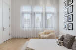 This bright and airy bedroom features sheer white curtains that allow natural light to flood the space, creating a serene atmosphere.