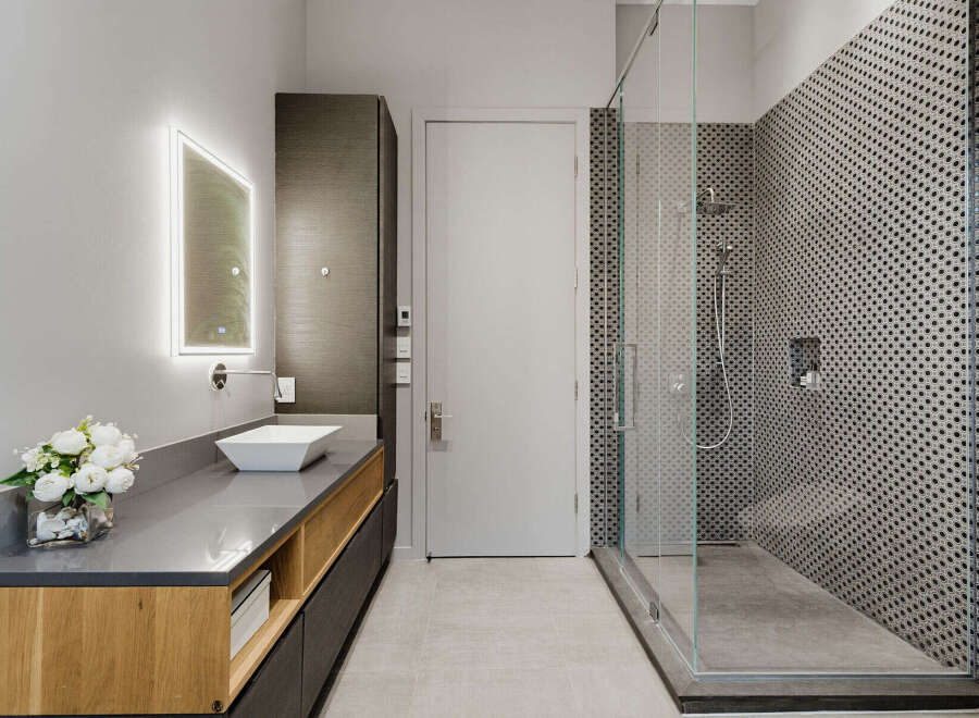 Experience modern luxury in this stunning bathroom featuring a sleek vanity with a vessel sink and integrated lighting.