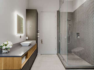 Experience modern luxury in this stunning bathroom featuring a sleek vanity with a vessel sink and integrated lighting.