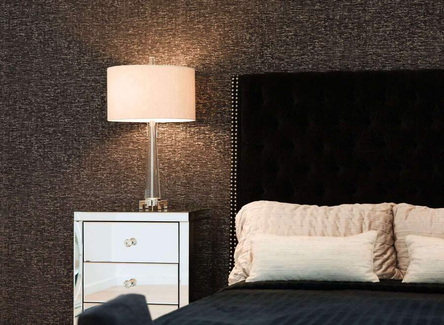 Experience luxury and comfort in this master bedroom, featuring a stunning tufted headboard and elegant mirrored nightstand.