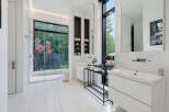 Experience luxury in this modern bathroom featuring a spacious walk-in shower with a scenic garden view.