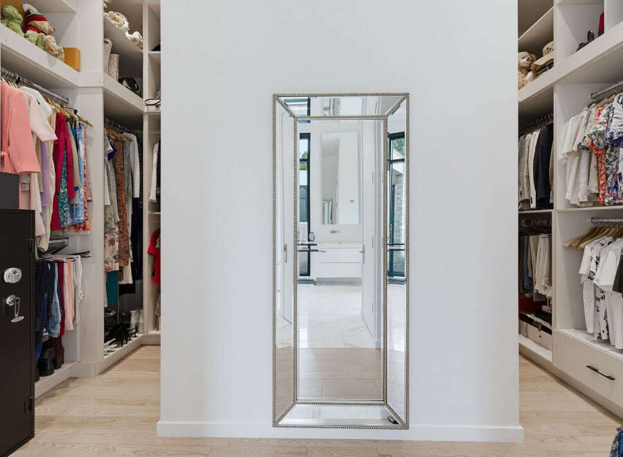 Step into this luxurious walk-in closet, featuring ample storage with custom shelving and hanging space for your extensive wardrobe.