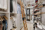 Experience unparalleled organization in this luxurious walk-in closet, featuring a custom ladder for easy access to upper shelves.