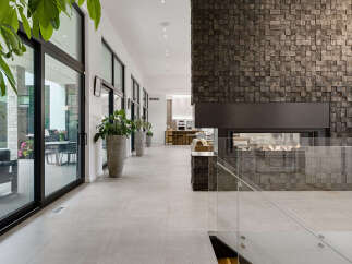 Experience modern luxury in this stunning home featuring a dramatic stone-clad fireplace as the centerpiece of the living space.