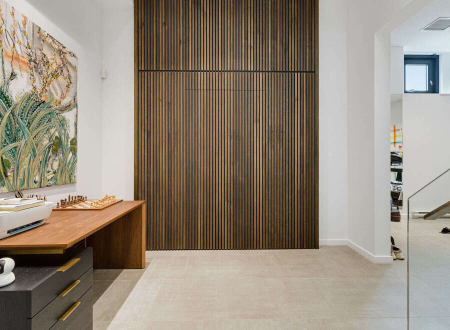 This modern home office features a striking slatted wood accent wall, creating a warm and inviting atmosphere.