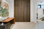 This modern home office features a striking slatted wood accent wall, creating a warm and inviting atmosphere.