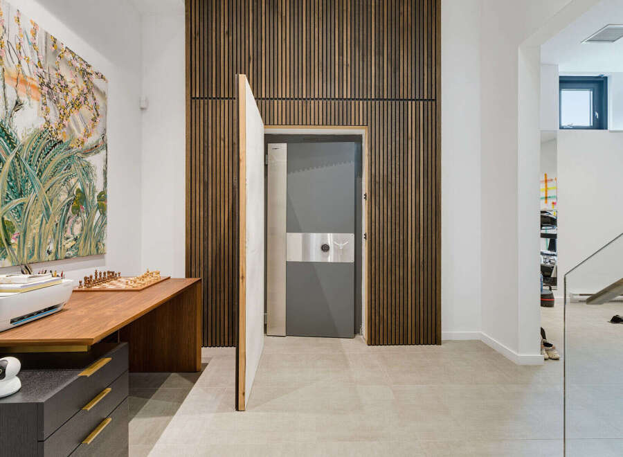 Discover a unique blend of modern design and security with this striking interior featuring a hidden vault door.