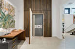 Discover a unique blend of modern design and security with this striking interior featuring a hidden vault door.