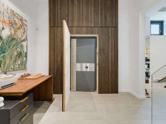 Discover a unique blend of modern design and security with this striking interior featuring a hidden vault door.