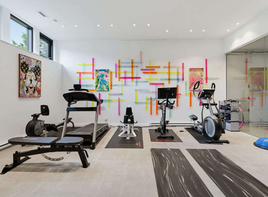 This modern home gym features a variety of cardio equipment including a treadmill, elliptical, and stationary bike, perfect for a full-body workout.
