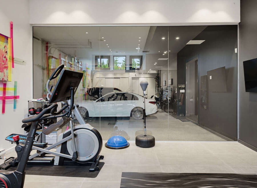 Experience the ultimate in home fitness with this state-of-the-art gym, complete with an elliptical and punching bag.