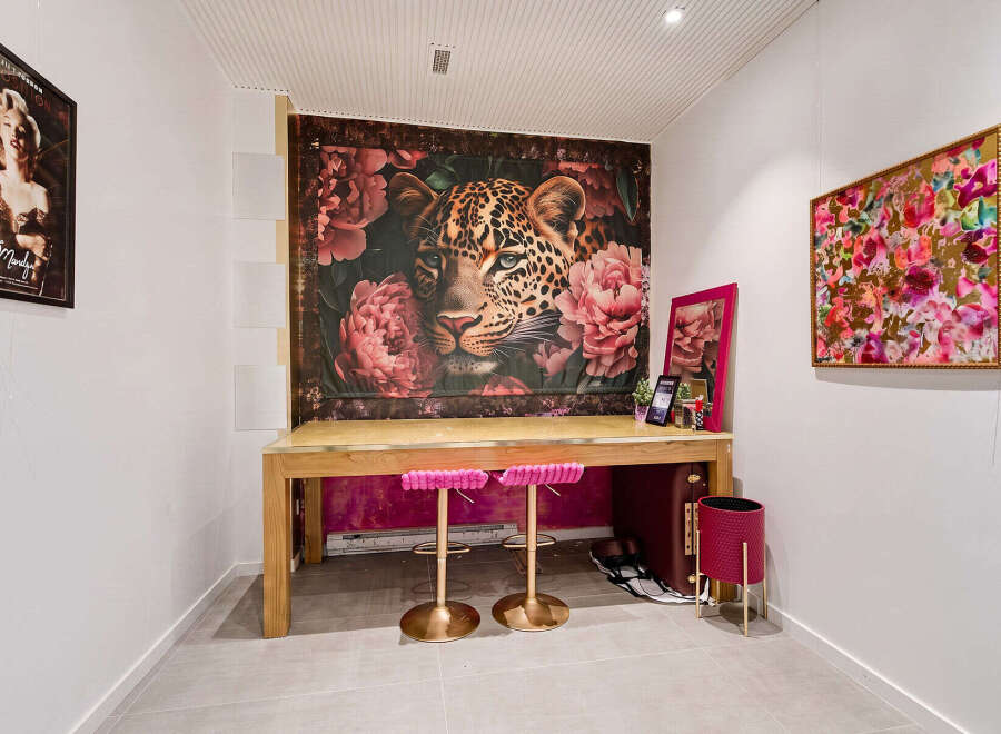 This stylish room features a striking leopard and floral tapestry as a backdrop to a modern wooden desk.