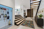 Step into a modern entryway featuring a floating staircase with wooden treads and a sleek black metal frame.