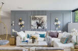 Experience modern luxury in this stunning living room, featuring a plush white sectional sofa adorned with elegant throw pillows and a cozy blanket.