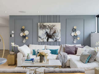 Experience modern luxury in this stunning living room, featuring a plush white sectional sofa adorned with elegant throw pillows and a cozy blanket.