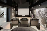 Experience ultimate entertainment in this luxurious home theater, featuring plush leather recliners and a large projection screen for an immersive viewing experience.
