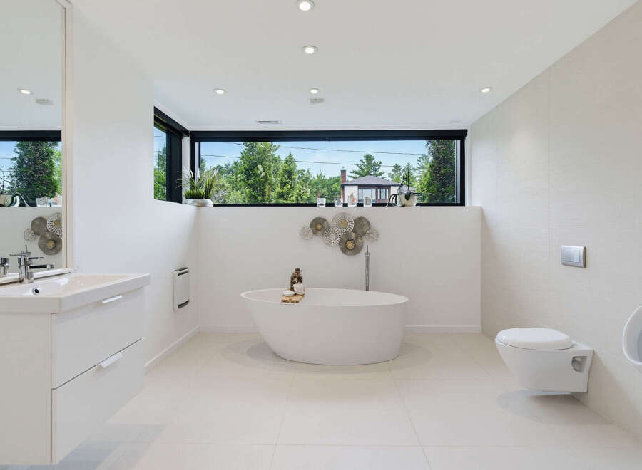 Experience modern luxury in this stunning bathroom featuring a sleek freestanding bathtub and a floating vanity.