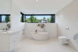 Experience modern luxury in this stunning bathroom featuring a sleek freestanding bathtub and a floating vanity.