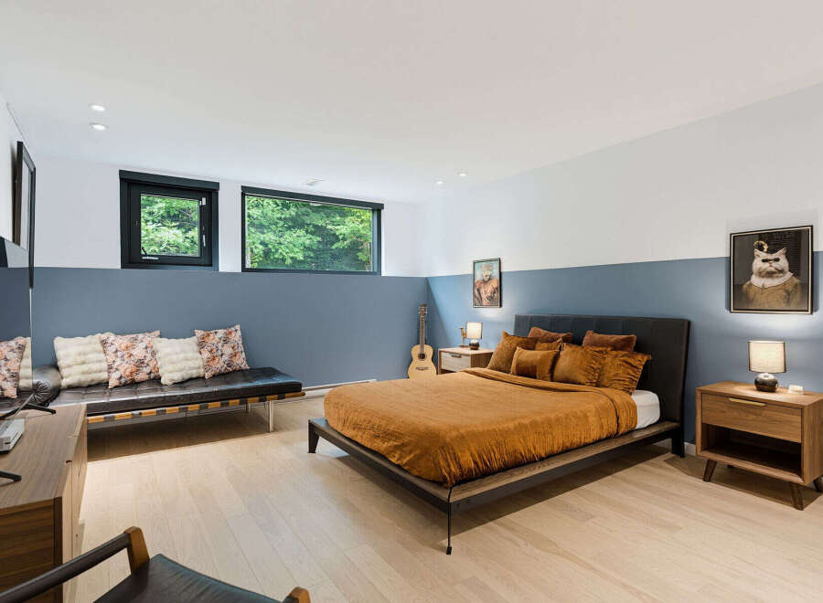 Experience modern comfort in this stylish bedroom, featuring a plush orange duvet on a sleek platform bed.