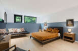 Experience modern comfort in this stylish bedroom, featuring a plush orange duvet on a sleek platform bed.