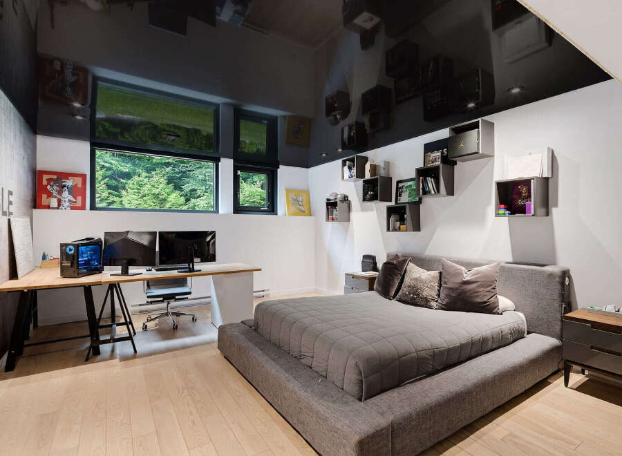 This modern bedroom features a sleek design with a glossy black ceiling reflecting the room's elements.