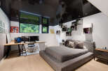 This modern bedroom features a sleek design with a glossy black ceiling reflecting the room's elements.