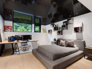 This modern bedroom features a sleek design with a glossy black ceiling reflecting the room's elements.