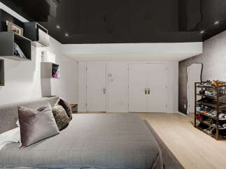 Discover modern living in this stylish bedroom featuring a sleek, dark ceiling and integrated shelving for a minimalist aesthetic.