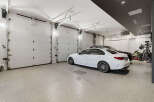 This spacious garage features multiple overhead doors, providing ample space for vehicles and storage.