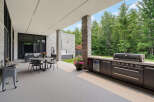 Experience luxurious outdoor living with this expansive patio featuring a built-in grill, beverage cooler, and comfortable dining area.