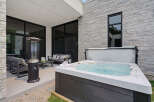 Experience luxury outdoor living with this stunning patio featuring a modern hot tub perfect for relaxation.
